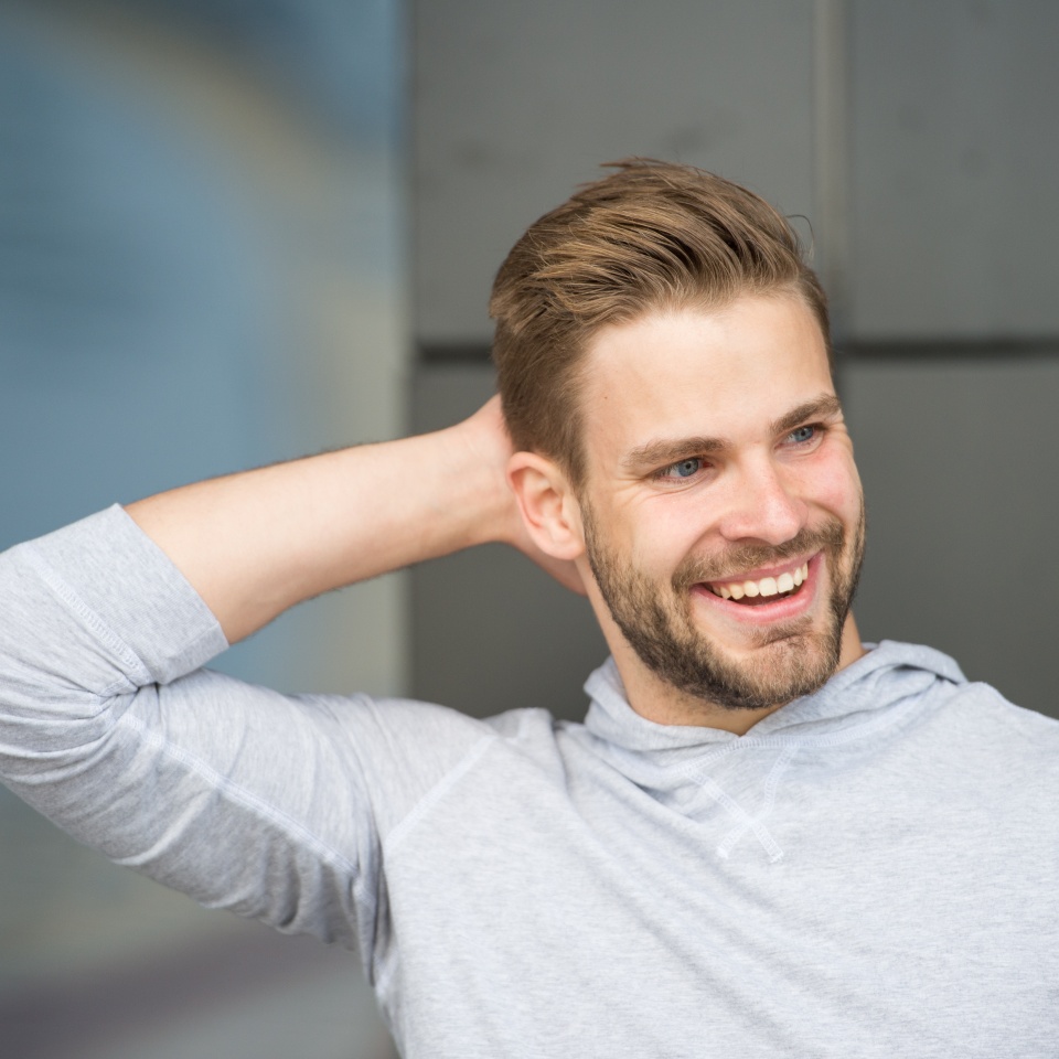 Man confident in his antiperspirant. Prevent, reduce perspiration. No sweat - deodorant works. Guy checks dry armpit satisfied with clean clothes. Sportsman after training pleased with antiperspirant.