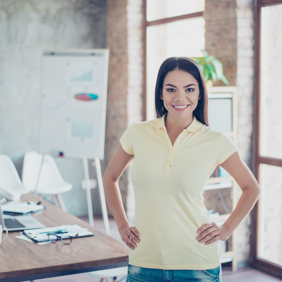 Portrait of beautiful smiling successful young hispanic businesswoman standing at her office