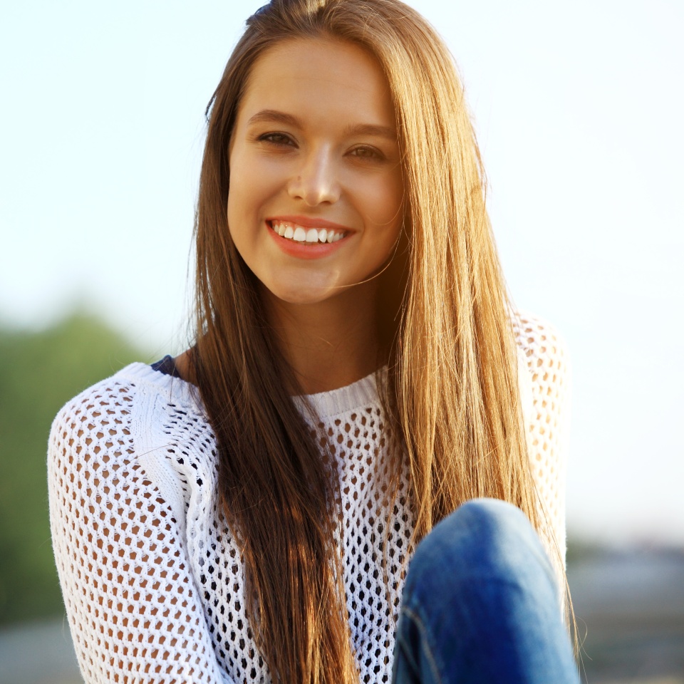 Portrait Of Young Smiling Beautiful Woman. Close-up portrait of a fresh and beautiful young fashion model posing outdoor. Summer outdoor portrait