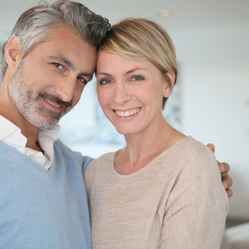 Smiling middle-aged couple standing in brand new home